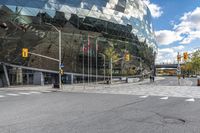 there is a large building that has a green facade at the front with trees and cars in front