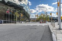 there is a large building that has a green facade at the front with trees and cars in front