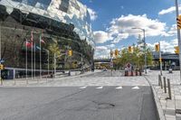 there is a large building that has a green facade at the front with trees and cars in front