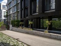 a black building with several rows of glass windows on a sunny day in paris, france