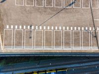 a train sits at the platform for people to board the tracks or walk on the rails