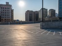 several large empty parking spaces in the city with buildings nearby in front of them -