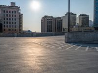 several large empty parking spaces in the city with buildings nearby in front of them -