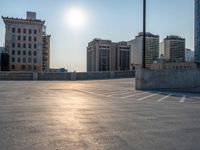 several large empty parking spaces in the city with buildings nearby in front of them -