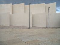 empty area outside concrete building with no people or vehicles at the entrance to area behind it