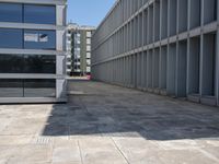 an empty room in front of a building with windows on both sides and a sidewalk behind