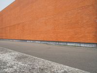 a red brick building with an empty lot in front of it in summer day,