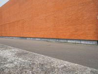 a red brick building with an empty lot in front of it in summer day,