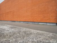 a red brick building with an empty lot in front of it in summer day,