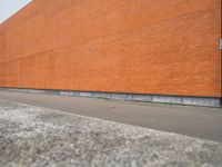 a red brick building with an empty lot in front of it in summer day,