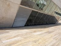 there is a shadow of a building behind the flooring pieces of wood on the floor
