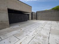 a concrete garage with open garage doors and a paved surface in between the bricks and cement