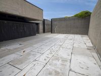 a concrete garage with open garage doors and a paved surface in between the bricks and cement