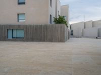 empty area outside concrete building with no people or vehicles at the entrance to area behind it