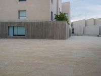 empty area outside concrete building with no people or vehicles at the entrance to area behind it