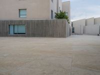 empty area outside concrete building with no people or vehicles at the entrance to area behind it