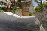 the stairs lead up to an apartment building, which appears to be on a hillside side