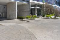 the empty parking lot near the building is empty of people or cars while in the front is a red fire hydrant and several trees