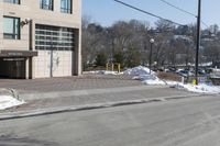 a parking garage on the side of a road in front of a building with lots of snow