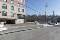 a parking garage on the side of a road in front of a building with lots of snow