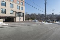 a parking garage on the side of a road in front of a building with lots of snow