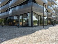 an outside view of a building with lots of glass walls and a stone pathway lined up