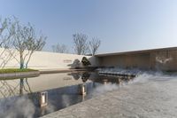 a fountain is shown with hot water on a paved area beside it with trees in the background