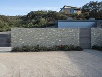 the house is next to a concrete wall and trees in a neighborhood that has not been built