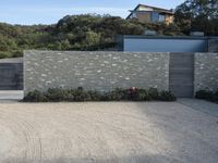 the house is next to a concrete wall and trees in a neighborhood that has not been built