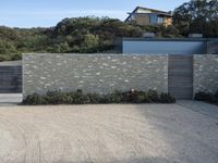 the house is next to a concrete wall and trees in a neighborhood that has not been built