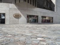 an empty street with brick tiles in front of a building with a large sign that reads,