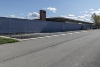 a building is on the side of a road with gravel and rocks around it and a truck driving by it