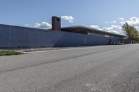 a building is on the side of a road with gravel and rocks around it and a truck driving by it