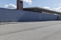 a building is on the side of a road with gravel and rocks around it and a truck driving by it