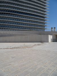 a black fire hydrant is sitting in the concrete area in front of a large building