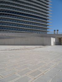 a black fire hydrant is sitting in the concrete area in front of a large building