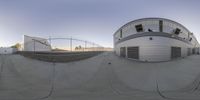 a fish eye lens view of a school with a tennis court and skateboard park in the background