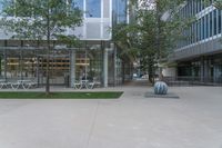 a large glass walled building has many tables and chairs on it's patio area