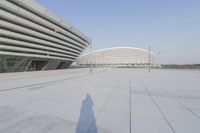 a view from inside an empty building that is white and has a curved walkway in front of it