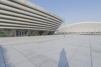 a view from inside an empty building that is white and has a curved walkway in front of it