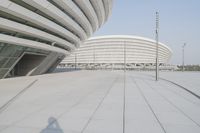 a view from inside an empty building that is white and has a curved walkway in front of it