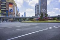 a city with a highway bridge, clock tower and many buildings in the background and a sculpture on a sidewalk