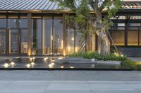 several candles lit at the end of a courtyard area with trees in the background,