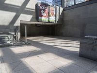 the empty area of an indoor building with steps and a bench at the entrance that is near it