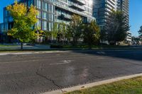 an empty city street in front of a large building that has a glass - walled top