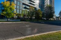 an empty city street in front of a large building that has a glass - walled top