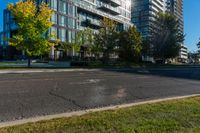 an empty city street in front of a large building that has a glass - walled top