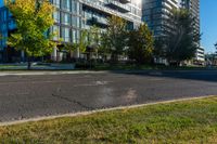 an empty city street in front of a large building that has a glass - walled top