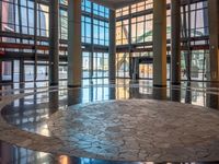 a very nice lobby with some big windows and marble floors all around it's