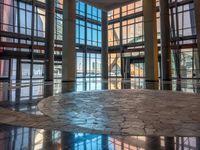 a very nice lobby with some big windows and marble floors all around it's